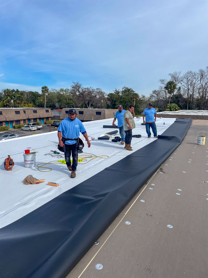 Roofing crew working on commercial flat roof