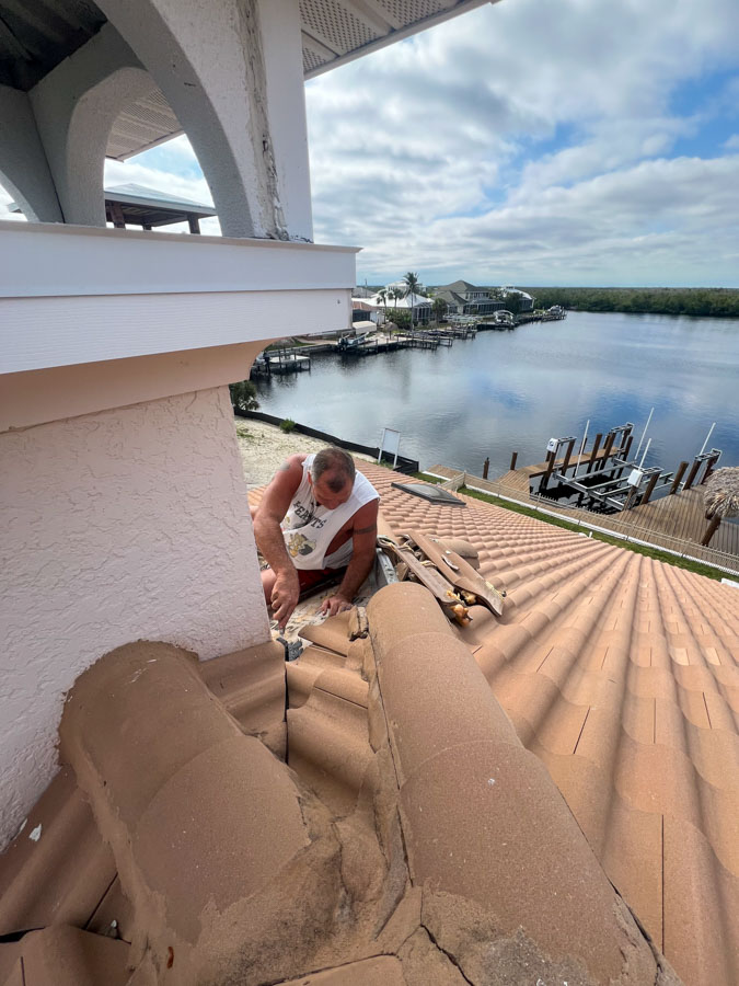 Roofer repairing clay tile roof near waterfront